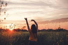 woman waving her hands during golden hour